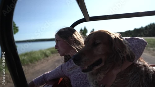 A woman and her dog driving on the beach photo