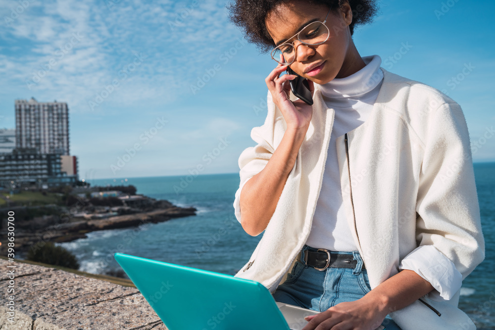 Woman using her laptop and talking on phone. Woman using her laptop and talking on phone.