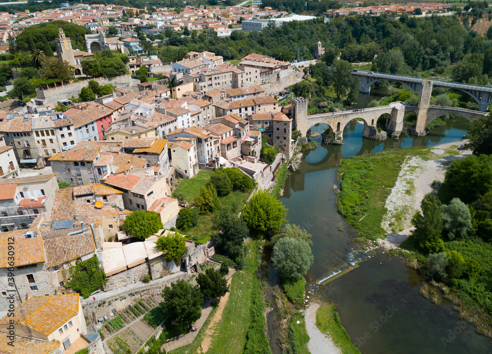 Panoramic view from drone of fortified village of Besalu with Fluvia river and medieval arched bridge, Spain.
