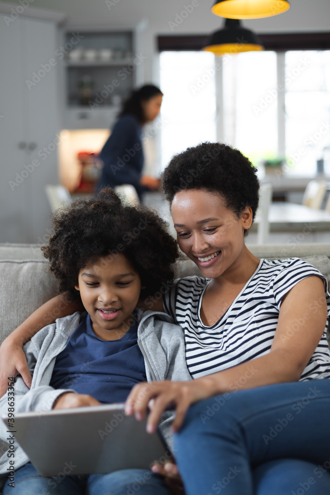 Mixed race woman and daughter sitting on couch Mixed race woman and daughter sitting on couch