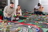 Young couples play a game slot car racing track. High quality photo