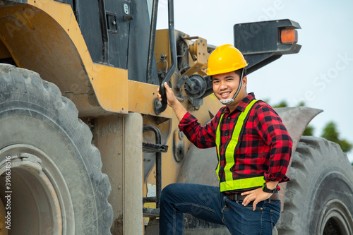 Happy asian driver wear safety uniform backhoe excavator and bulldozer on construction site