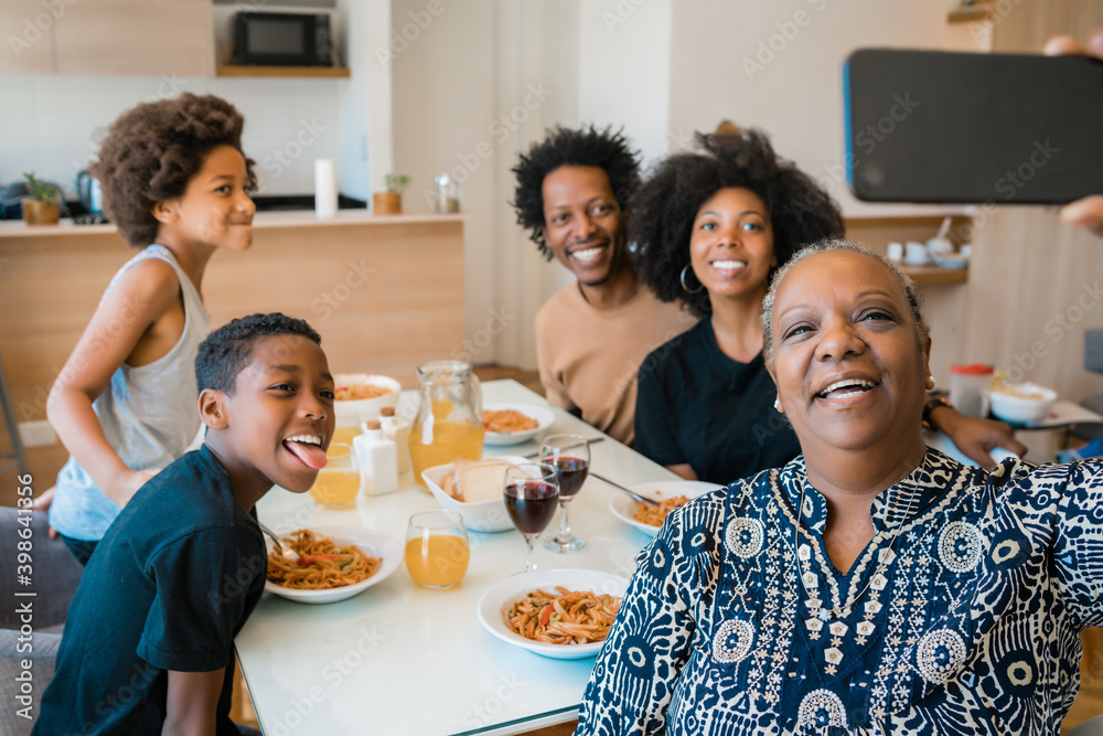 Multigenerational family taking selfie with phone at home.