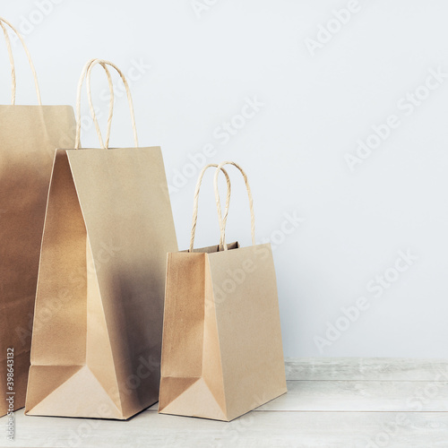  with buff paper shopping carry bags on grey. online delivery service of goods and grocery, internet shopping. Environment and eco friendly packaging, plastic free takeaway. lockdown