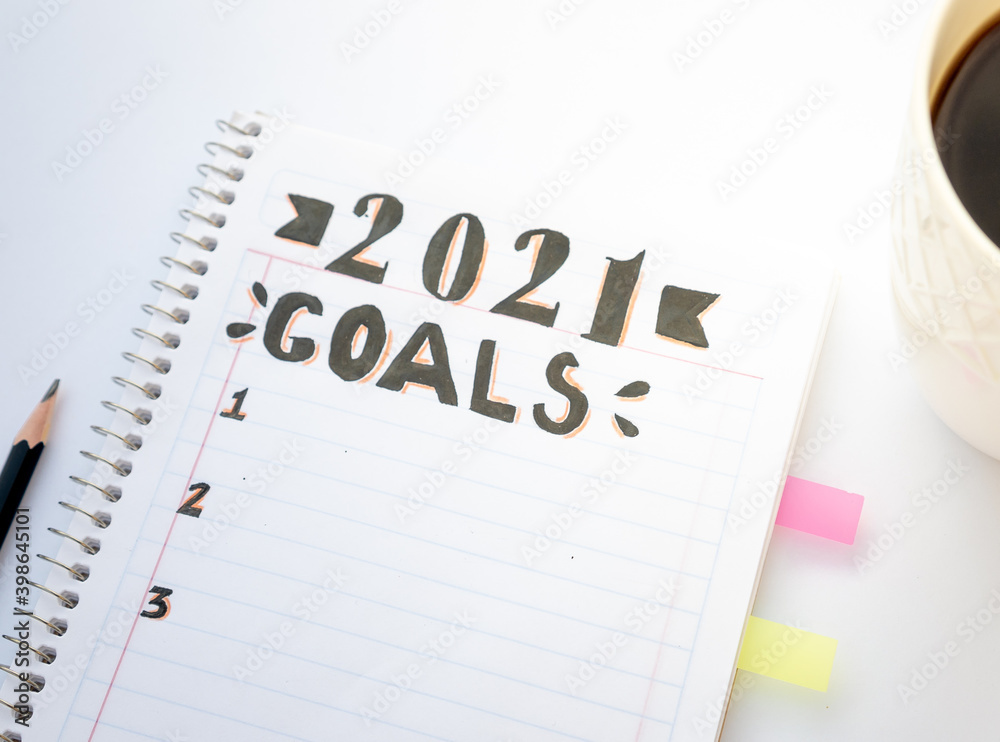 Decorated notebook for writing New Year's resolutions on a white table. Decorated notebook for writing New Year's resolutions on a white table.