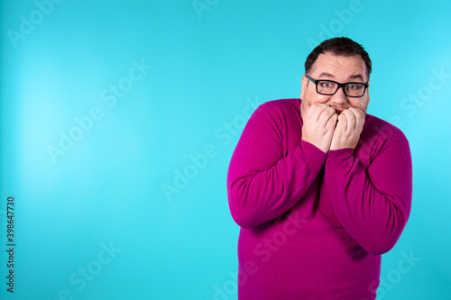 Fear and excited face. Young handsome man with beard wearing casual sweater and glasses. Afraid and shocked with surprise and amazed expression. 
