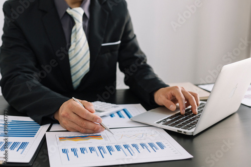 Business women are analyzing and evaluating marketing for a company using graphs on their desks in the office Concept of business risk analysis and assessment