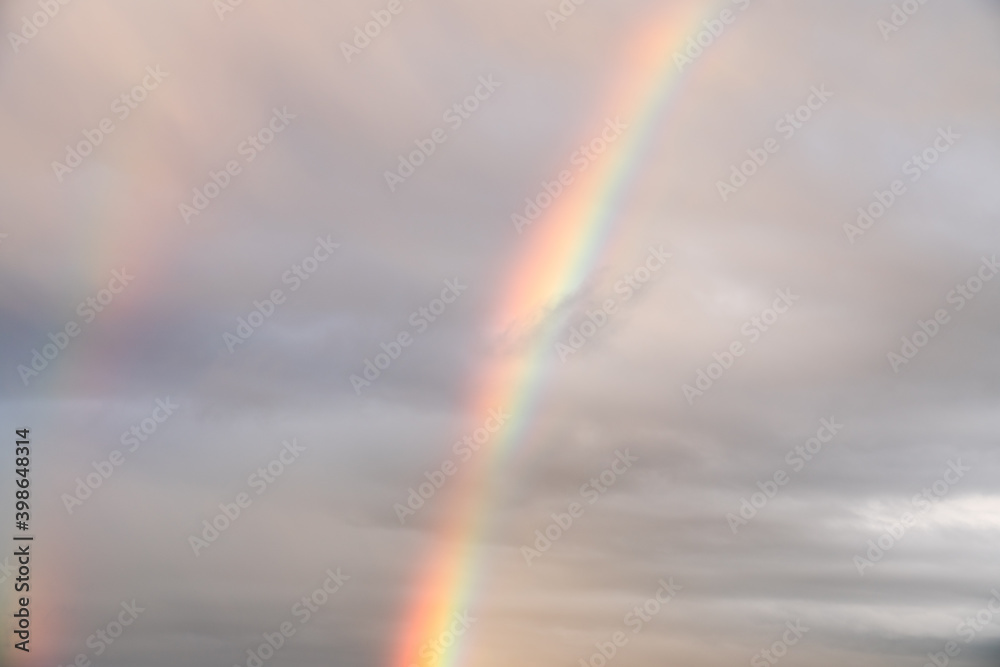 Rainbow on cloudy sky after rain