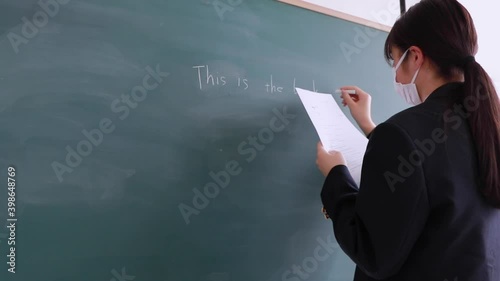 板書するマスクをつけた女子学生