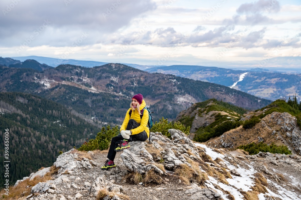 A female traveler sits on top. Beautiful mountain and hilly landscape.