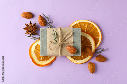 Natural handmade soap with orange, almond and cinnamon on violet background
