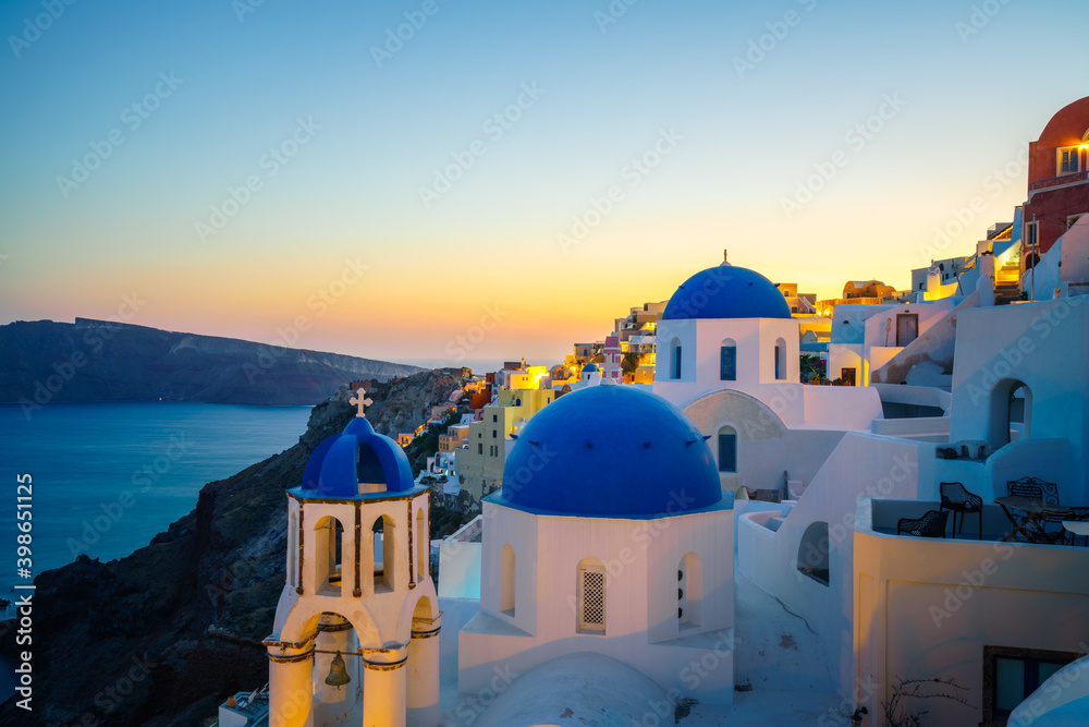 Beautiful sunset view of blue domes of Oia in Santorini island, Greece
