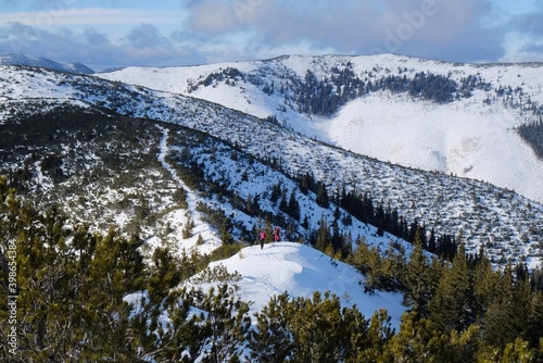 Beautiful mountain winter view during a snowshoe trip from Certovica to Dumbier - the highest peak of the Low Tatras in Slovakia. Silhouette of tourists on hill. photo