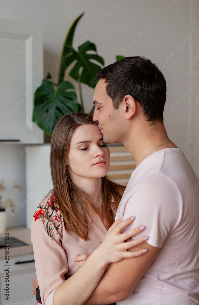 husband kissing and hugging wife in kitchen husband kissing and hugging wife in kitchen