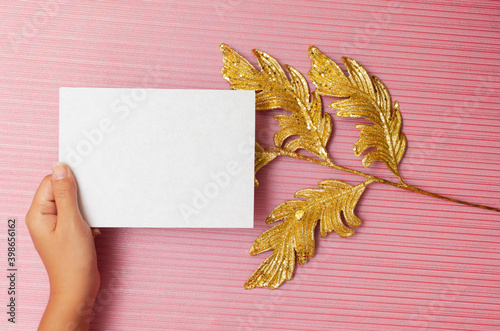 Blank card with christmas decoration on textured pink background. Card mockup.