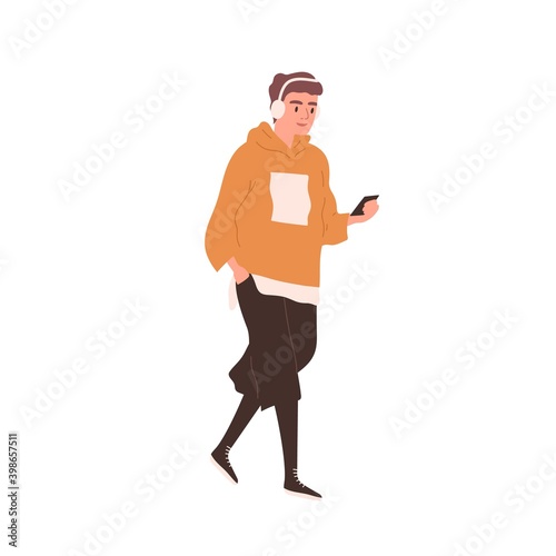 Young smiling man walking and listening to music in headphones. Male character in street style outfit holding smartphone. Flat vector cartoon illustration of stylish guy isolated on white background