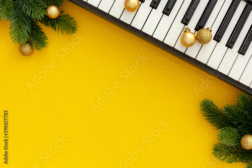 Synthesizer with Christmas decor toys and spruce branch. Christmas music.