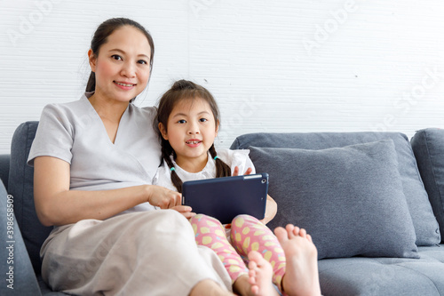Mother and daughter using digital tablet together.
