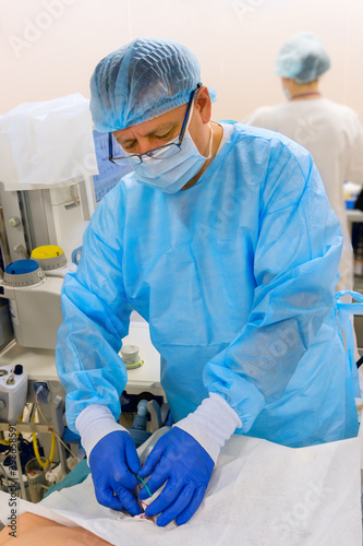 Doctor inserts double lumen catheter in jugular vein