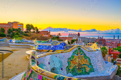 Beautiful sunrise in Barcelona seen from Park Guell. Park was built from 1900 to 1914 and was officially opened as a public park in 1926. In 1984, UNESCO declared the park a World Heritage Site