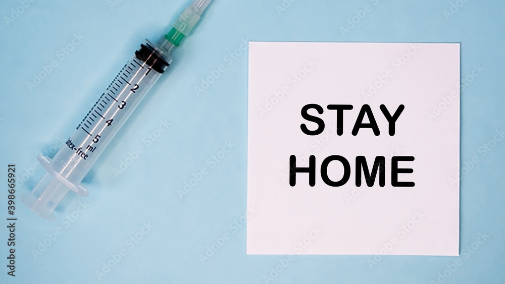 'Stay home' message on sticker with syringe near. Medical concept. 'Stay home' message on sticker with syringe near. Medical concept.