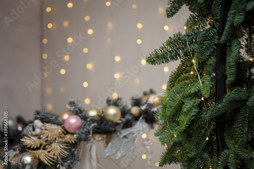 Soft focused shot of fir branches on festive Merry Christmas and Happy New Year background. Warm golden garland lights bokeh. Winter holidays template, copy space