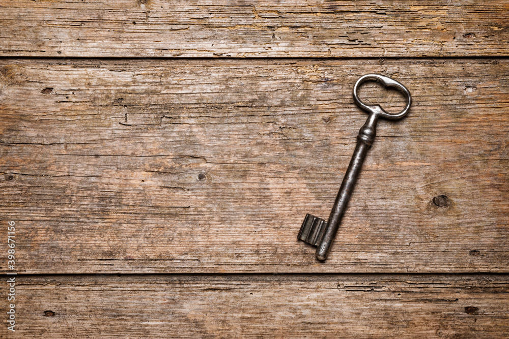 Old key on rustic wooden background with copy space Old key on rustic wooden background with copy space