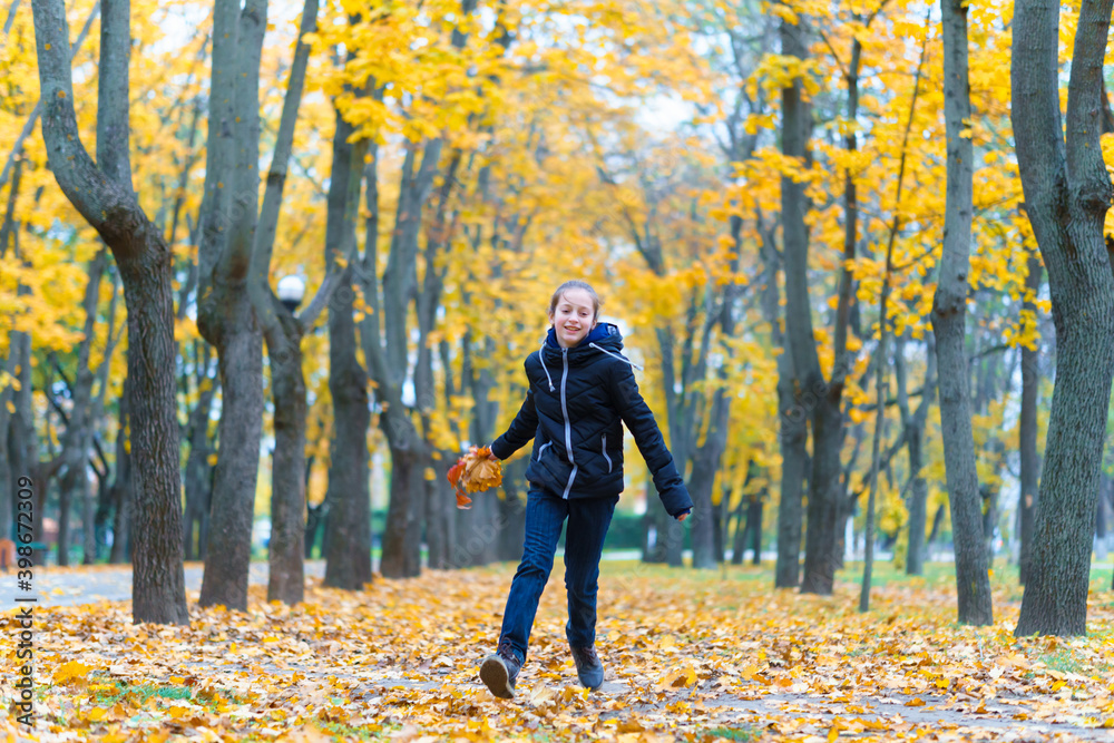 a girl running through the park and enjoys autumn, beautiful nature with yellow leaves a girl running through the park and enjoys autumn, beautiful nature with yellow leaves