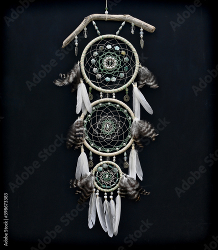 Beautiful boho styled dreamcatcher with feathers against black.