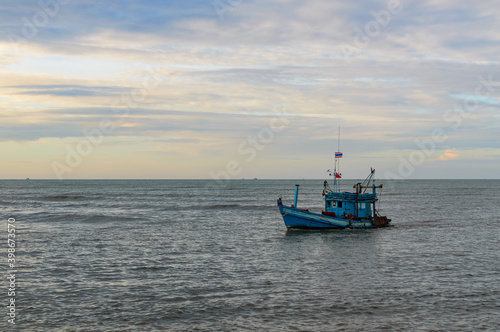 A lonely wooden fishing boat returns to the village after night catching at dawn