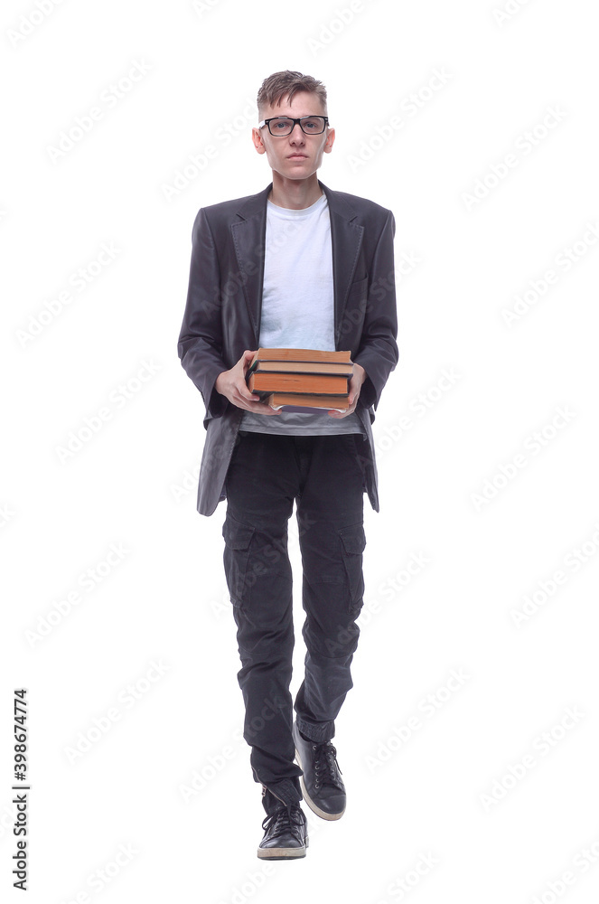 in full growth. serious guy with a stack of books striding forward. in full growth. serious guy with a stack of books striding forward.