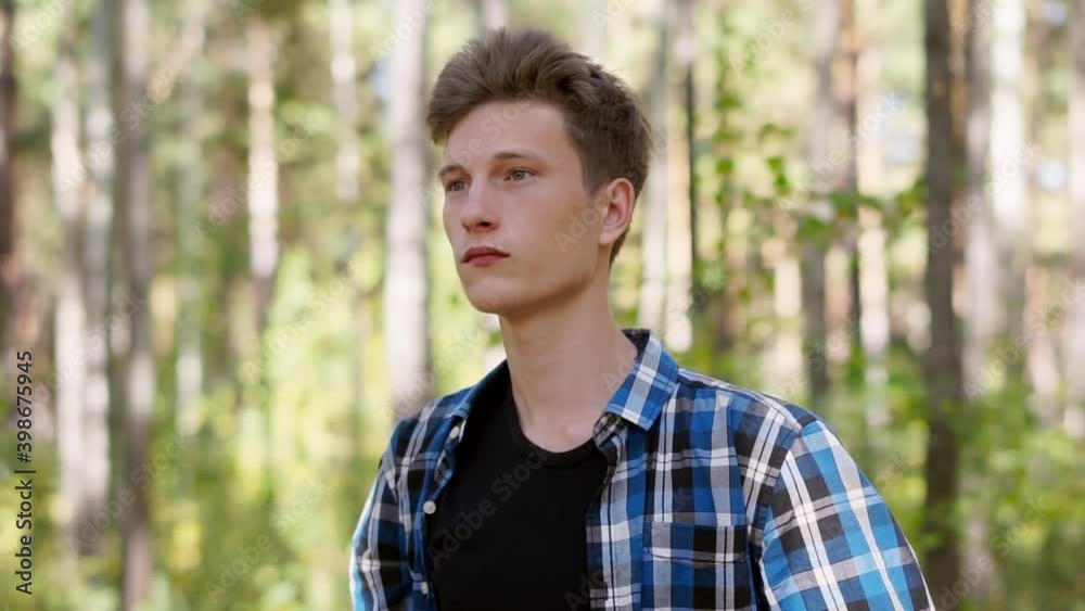 Guy in a blue plaid shirt beautifully puts on a hat Guy in a blue plaid shirt beautifully puts on a hat