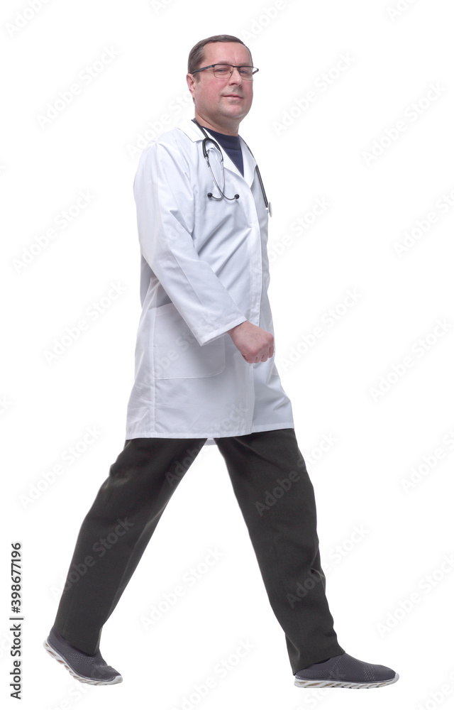 side view. male doctor with a stethoscope confidently walking forward.