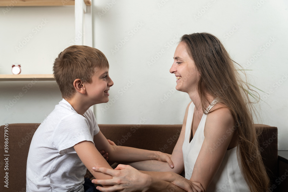 Fototapeta premium Mom and son hold hands and look into each others eyes. Good relationship with parents