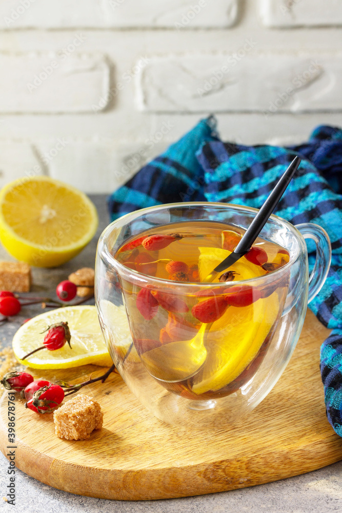 Vitamin winter drink. Hot tea rosehip dried with honey and lemon on a wooden table top. Copy space.