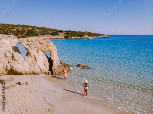 Tropical beach of Voulisma beach, Istron, Crete, Greece ,Most beautiful beaches of Crete island -Istron bay near Agios Nikolaos drone aerial view, couple walking on the ebach photo