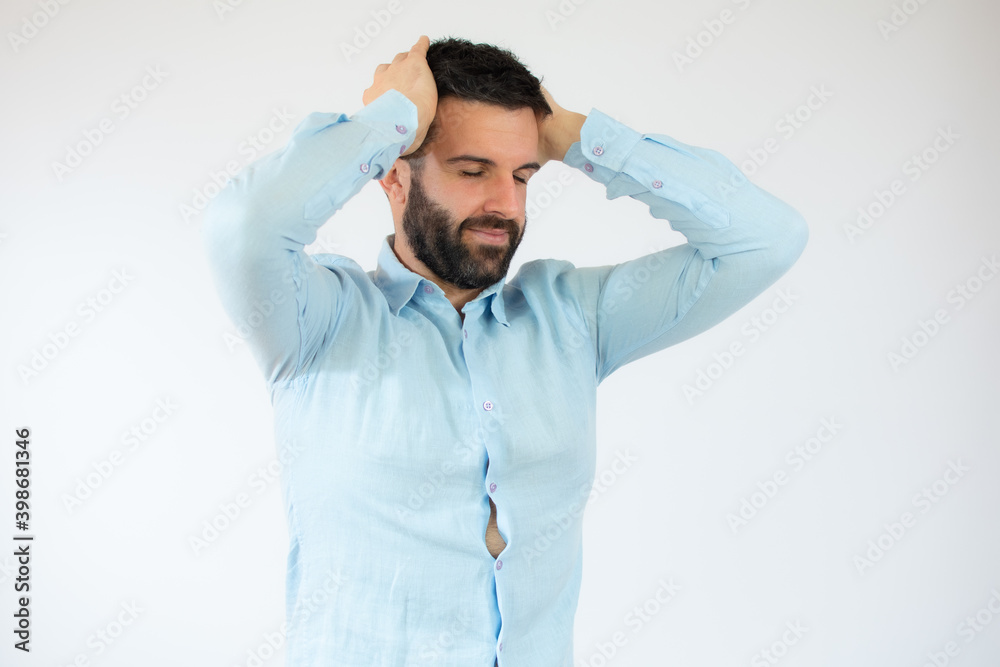 Young man wearing casual blue shirt with doubtful gesture over white background.