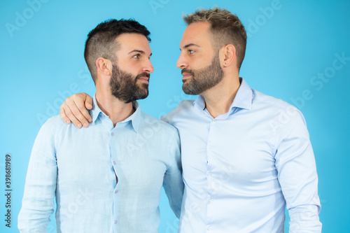 Young gay couple of two men wearing casual clothes hugging oneself happy and positive, smiling confident. self love and self care