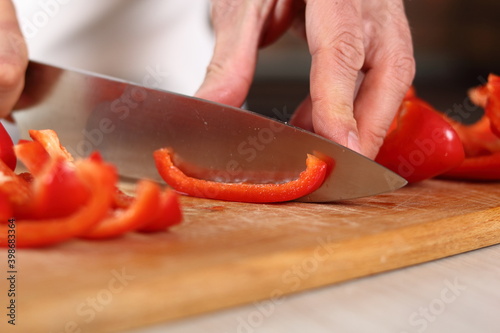 Chef slicing red bell pepper into strips. Making Chicken and Egg Galette Series.