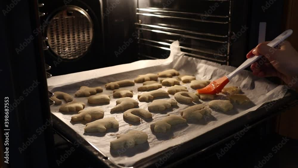 Putting Mixed Egg on Gingerbread Cookies in the Oven. Baking Process of Christmas Cookies. Putting Mixed Egg on Gingerbread Cookies in the Oven. Baking Process of Christmas Cookies.
