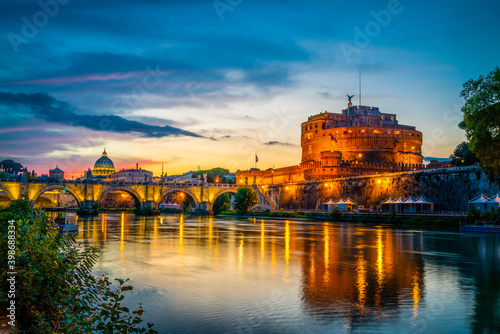 Saint Angelo castle and old bridge with St Peter's basilica in the background near Tiber River in Rome 