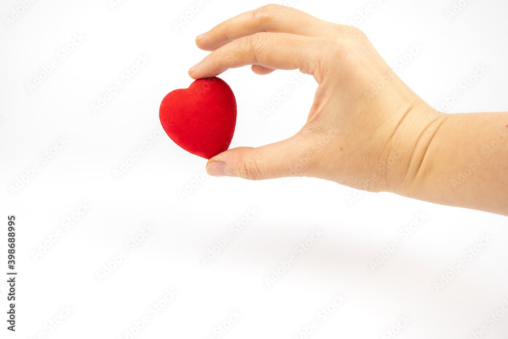 Fototapeta premium Red heart in a hand on white background