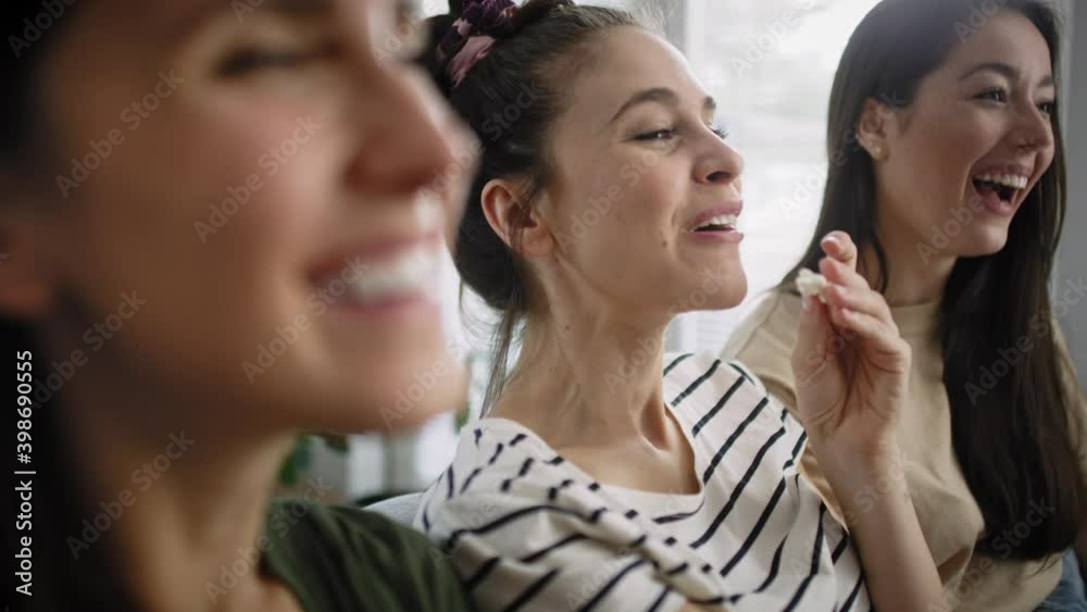 Zoom in video of happy women watching TV at home. Shot with RED helium camera in 8K. Zoom in video of happy women watching TV at home. Shot with RED helium camera in 8K.
