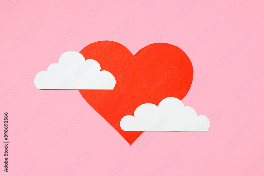 Valentine's Day concept. Red heart in the clouds on a pastel pink background. Greeting card design. Flat lay, top view, copy space