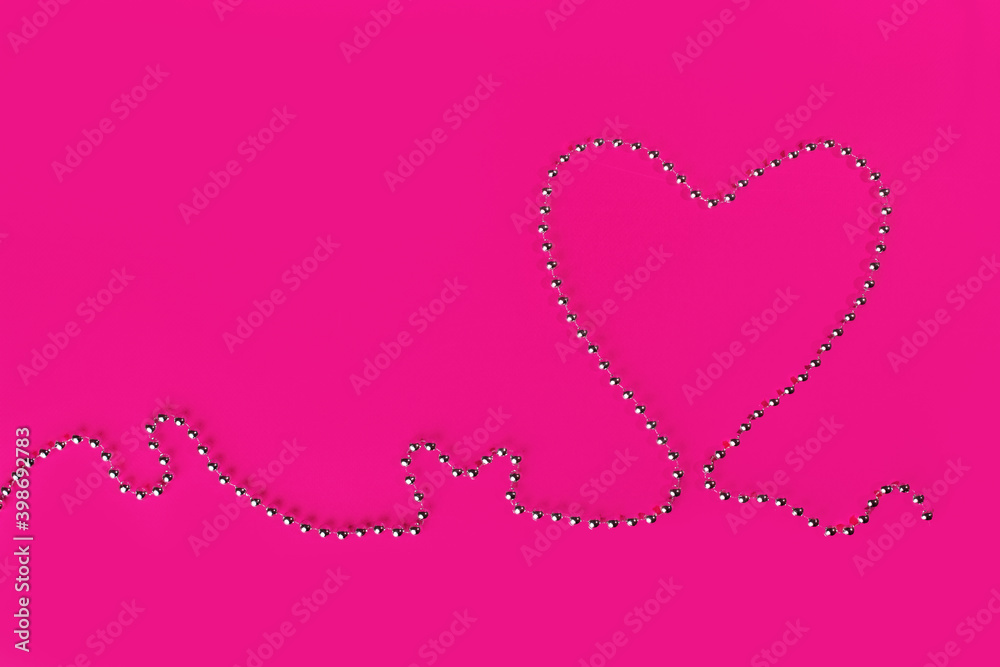 A heart-shaped beads on a fuchsia background. Valentine's Day symbol.