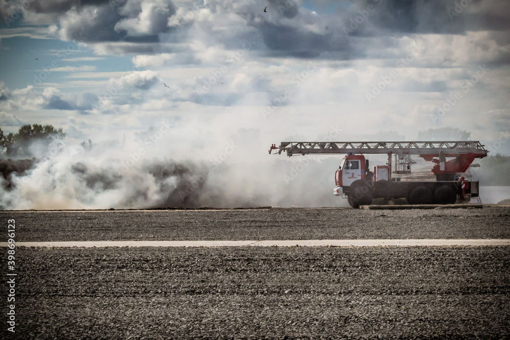 Fototapeta premium Russian fire truck in the smoke from the fire