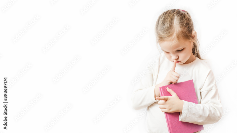 Little girl with a notebook in her hands is thinking about something. learning concept Little girl with a notebook in her hands is thinking about something. learning concept