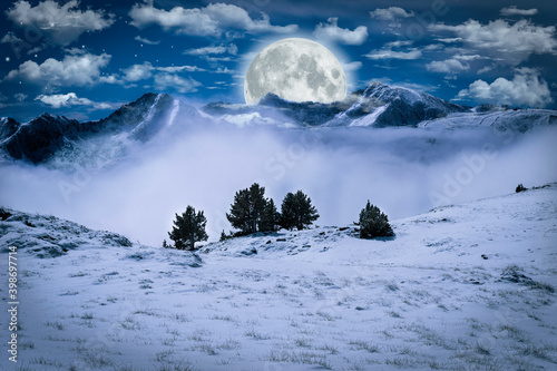 Montañas nevadas de noche con la luna encima