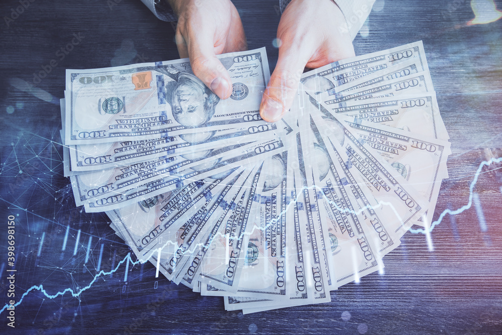Multi exposure of financial graph drawing hologram and USA dollars bills and man hands. Analysis concept. Multi exposure of financial graph drawing hologram and USA dollars bills and man hands. Analysis concept.