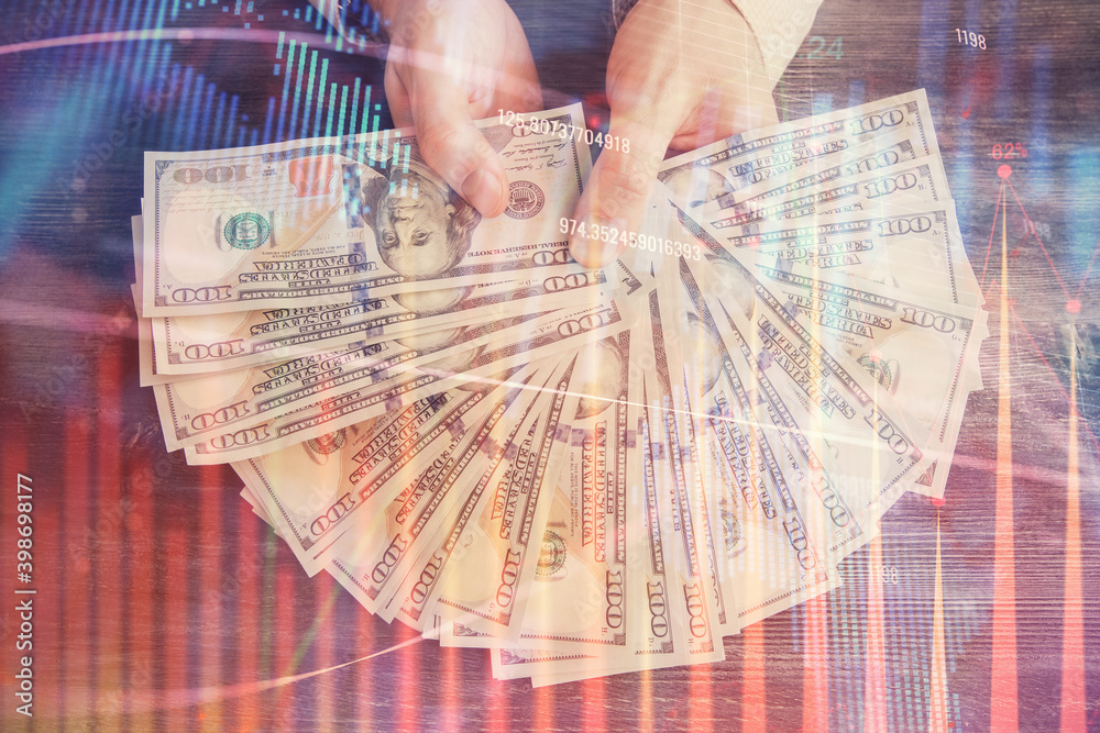 Multi exposure of financial graph drawing hologram and USA dollars bills and man hands. Analysis concept. Multi exposure of financial graph drawing hologram and USA dollars bills and man hands. Analysis concept.